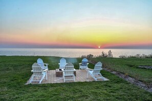 Adirondacks surround the fire pit at the edge of the bluff