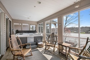 The screened in porch of the Master Bedroom has a Hot Tub and seating with water views!