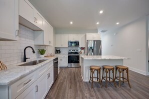 Full kitchen with stainless steel appliances and breakfast bar with seating for 3