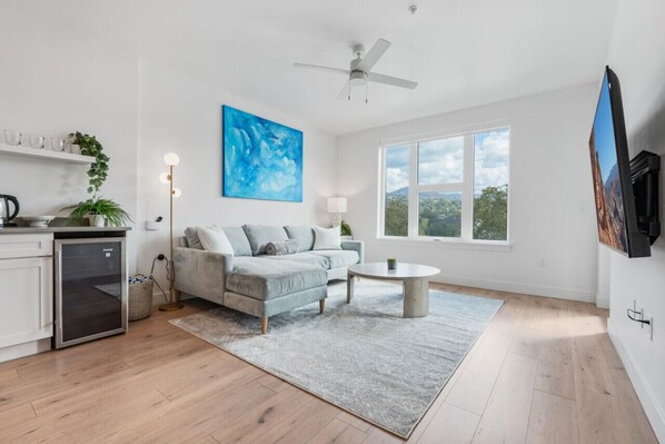 Beautifully designed living room. 65" TV, comfy sofa and amazing views of mountains and city skyline.