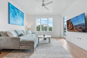 Beautifully designed living room. 65" TV, comfy sofa and amazing views of mountains and city skyline.
