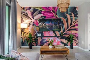 Step into paradise in our tropical-themed living room with a large smart TV!