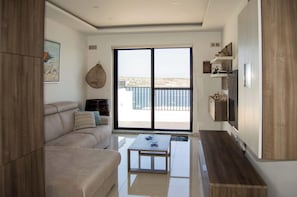 Living area leads to front terrace with magnificent sea views . Large sofa and 65 inch TV inside this room.