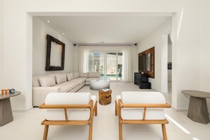 This stylish living room is furnished with designer sofas and chic accent chairs, creating a sophisticated space for relaxation.