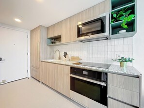 Kitchen with terrazzo counters, gold fixtures, and sleek built-in appliances.