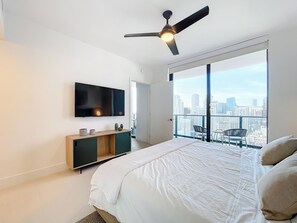 Bedroom with balcony views, modern decor, and outdoor sitting for relaxation.