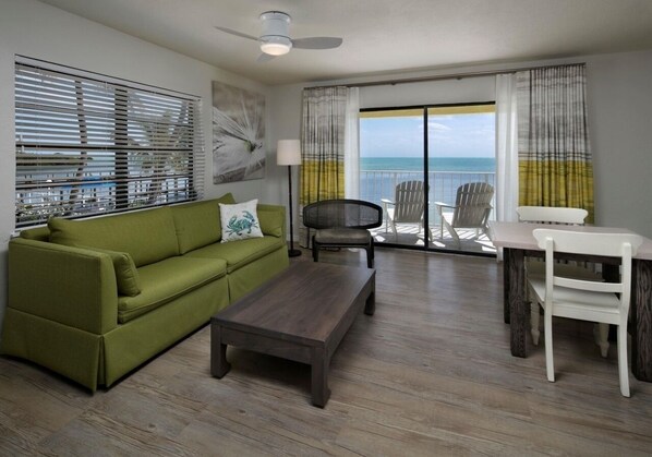 Living area with a sleeper sofa, balcony and direct beach access.