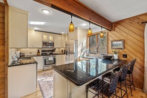 Warm and inviting kitchen to prep your meals, and enjoy coffee at the breakfast bar.