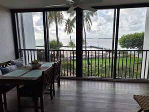 Balcony breakfast and dining area overlooking sandy beach with palm trees 