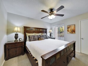 View of primary bedroom with king size bed, plush bedding and extra blankets and 42" flat screen TV