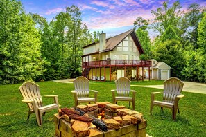 Charming cabin-style home with a spacious deck and a cozy outdoor fire pit, perfect for gatherings and relaxation