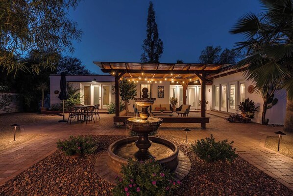 Romantic courtyard with lush landscaping and a fountain. 