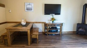 Relax in the spacious living area, equipped with a flat-screen TV and a cozy wood-burning stove.