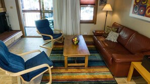 Spacious living room filled with natural light, offering cozy seating and a warm, welcoming atmosphere.