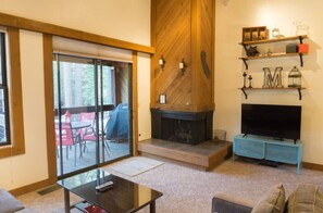 Spacious living room with a welcoming fireplace, perfect for relaxing evenings, and large windows for natural light.