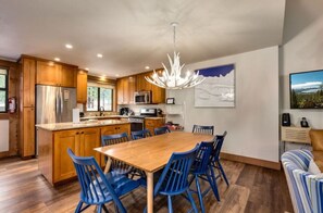 Elegant dining area with seating for six, featuring a stylish chandelier and wooden accents, ideal for family meals or entertaining guests.