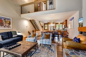 Open-concept living and dining area with a spacious layout, stylish furniture, and large windows providing plenty of natural light.