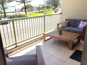 The chill balcony overlooking Rainbow Bay is complete with comfortable outdoor seating and is a great place to relax or have a sunset beer