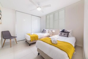 The second bedroom comfortably sleeps 2 more people in two single beds, and also enjoys a large built-in wardrobe
