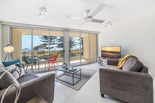 Direct beach view from the bright living area with cushy sofas, where you can relax or watch something on the large TV