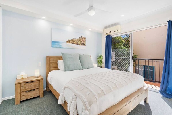 The primary bedroom highlights a king-sized bed and benefits from direct access to the balcony. 
