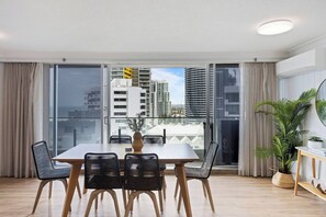 The light-filled dining area includes a six-seater table for guests to share meals together, with additional seating available at the breakfast bar.