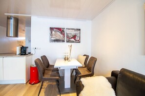 Beach House 21 – Heller Essplatz mit Kunst an der Wand und Blick zur Kochinsel.