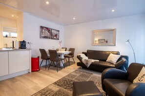 Beach House 21 – Moderner Essbereich trifft auf gemütliche Ledercouch – stilvoll kombiniert.