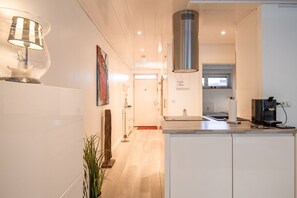 Beach House 21 – Heller Flur mit Blick in die Küche und ins Schlafzimmer.