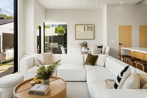 Step into a bright and airy living room bathed in natural light—perfect for relaxing or gathering with loved ones. Featuring a plush sofa, entertainment setup, and thoughtful design touches for your comfort and enjoyment.