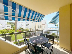 Sunny private terrace with sea views and dining area for four guests