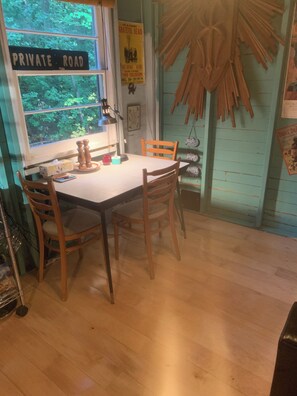 Cool retro table, seats for four.Open concept living area with wood floors.
