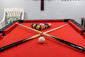 Exciting game room with a pool table, ping pong, darts, foosball, basketball game, Roku TV, and a small bar area—everything you need for a great time.