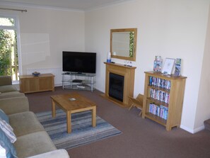 Large lounge with smart TV, DVD player and a large selection of films on DVD.