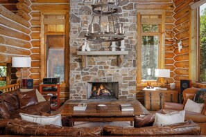 Main level living room area with comfortable seating, gas fireplace and deck access