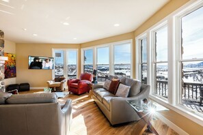 Relax in style with floor-to-ceiling windows showcasing sweeping mountain vistas, filling the space with natural light.