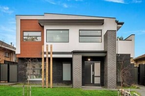 Charming front of house with lush greenery and inviting entrance for a warm welcome