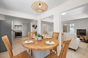 This inviting space features a beautifully crafted wooden dining table, surrounded by four stylish wooden chairs that provide both comfort and elegance.