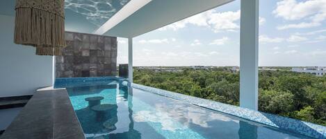 Covered outdoor pool with views of the surrounding greenery.