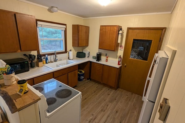 Kitchen cabinets stocked with cooking wares, glassware and silverwares, ideal for mixing up your favorite meals and drinks during your stay.