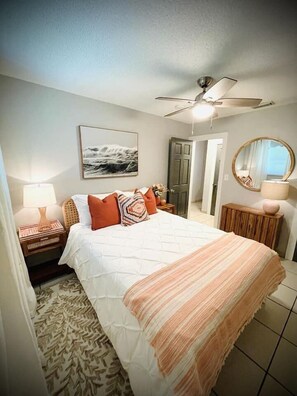 Comfy queen bedroom on the left with walk in closet, ceiling fan, and tv. 