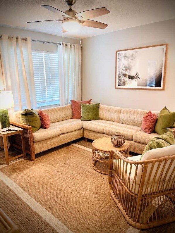 Beachy living room with plenty of seating and ceiling fan. 