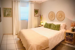 Spacious queen sized bed with ceiling fan and tv.