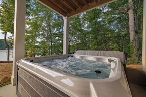 Relax in the private hot tub with serene lake views