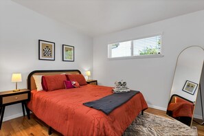 Bedroom with plush beddings and standing mirror