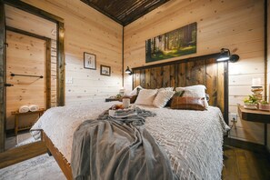 Inviting wooden bedroom with comfy bed and tranquil forest-themed accents.