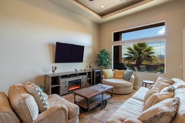 This lively living room features a neutral color palette that brings warmth and energy to the space. The open layout and fireplace provide a welcoming atmosphere for guests to gather and enjoy comfortable evenings.