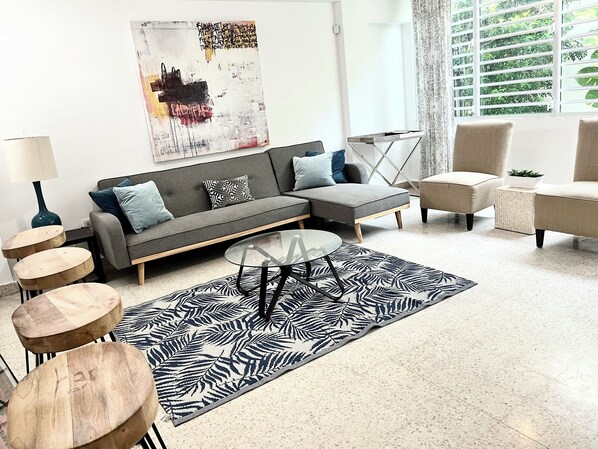Roomy and well lit living room with plenty of room for all. Also has a TV.