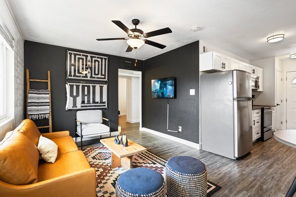 Unit 2: Bright and open living area with a Smart TV, designer furnishings and a dining table with seating for 2 guests.