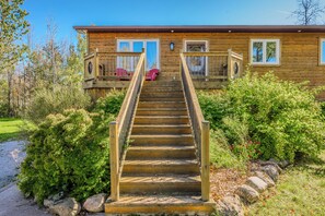 The front stairs leading up to the cozy entrance, framed by lush greenery.